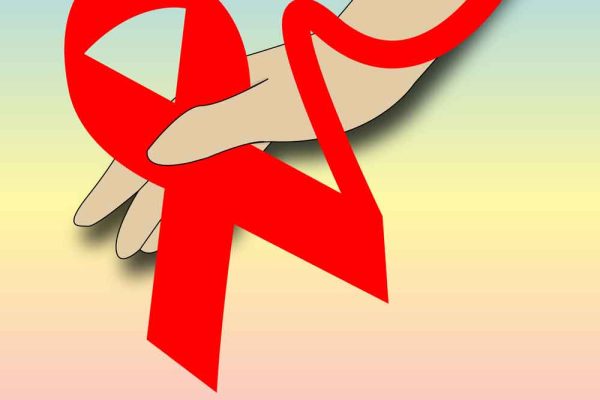 A hand with a red ribbon tied along the fingers and wrist.